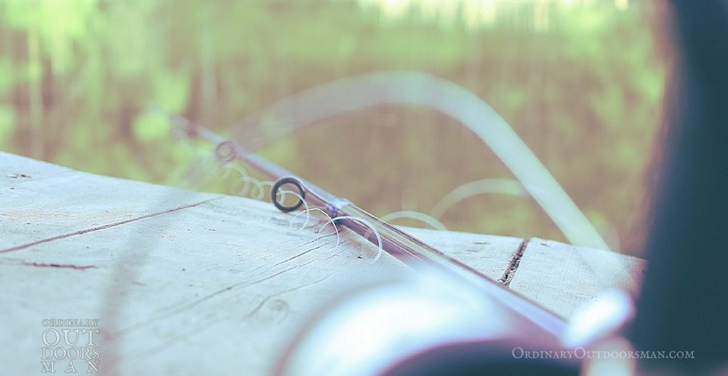 photo of a spinning reel and fishing pole sitting on a dock for free fishing days