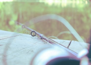 photo of a spinning reel and fishing pole sitting on a dock for free fishing days