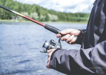 photo of man holding fishing pole - free fishing days in 2018