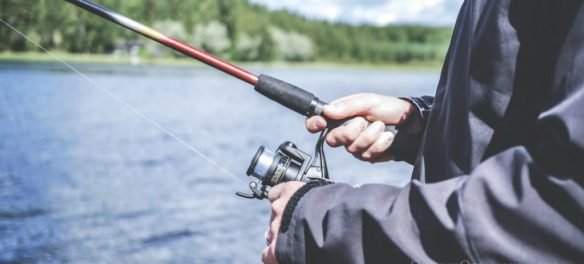 photo of man holding fishing pole - free fishing days in 2018