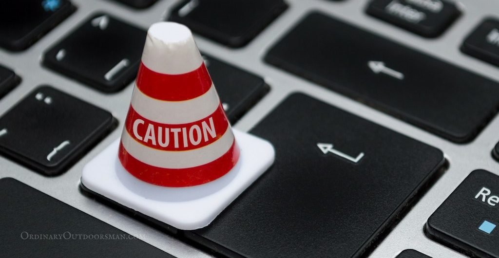 photo of a caution cone on a computer keyboard symbolizing being careful when Buying Fishing & Hunting Permits Online