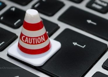 photo of a caution cone on a computer keyboard symbolizing being careful when Buying Fishing & Hunting Permits Online