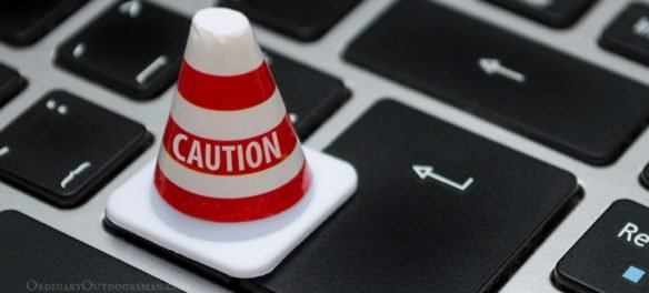 photo of a caution cone on a computer keyboard symbolizing being careful when Buying Fishing & Hunting Permits Online